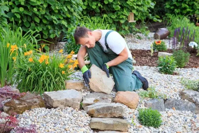 Crew member handling stone during landscape installation